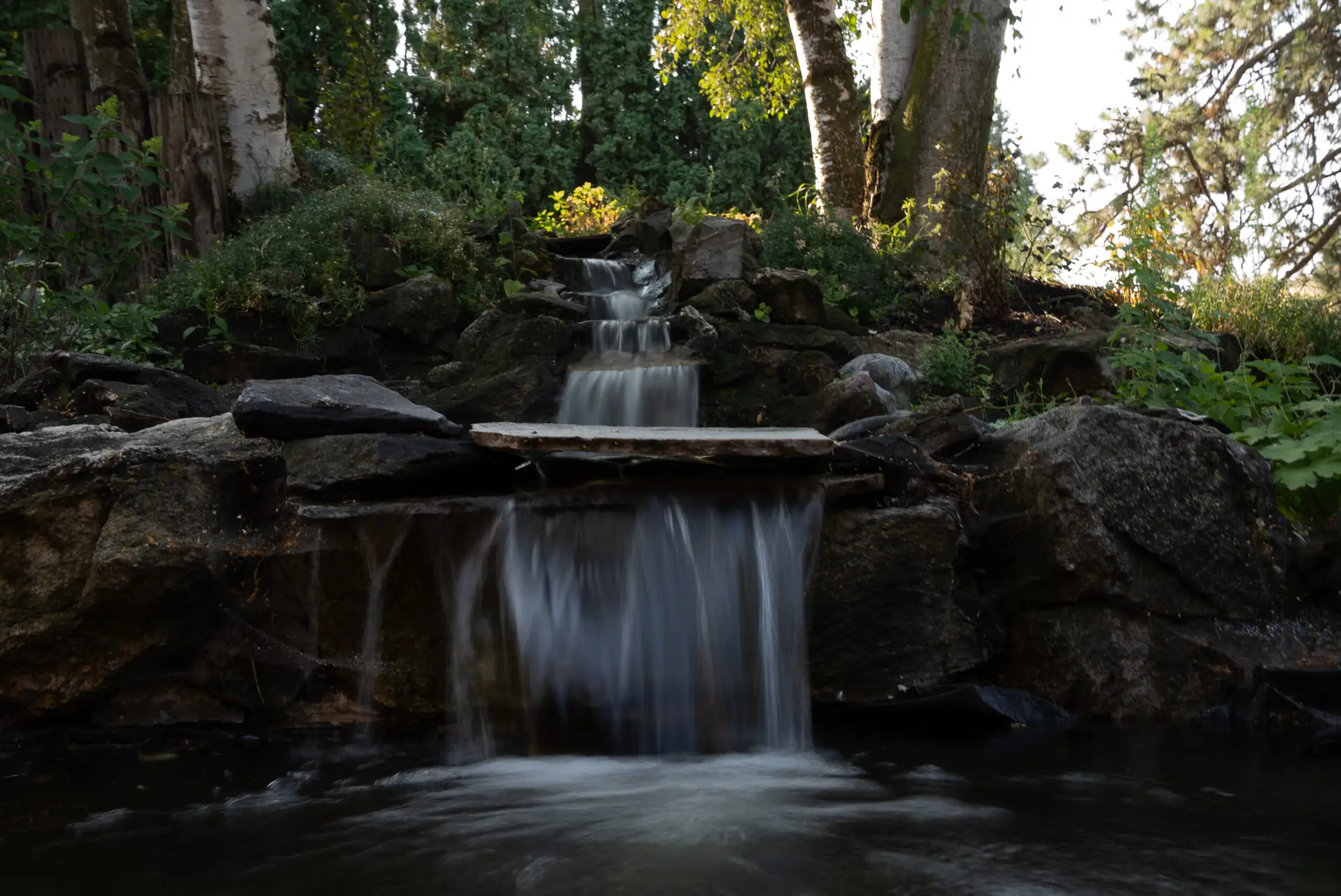 Pond with cascading waterfall and lush greenery at Barn Owl Venue in Valleyford, Washington