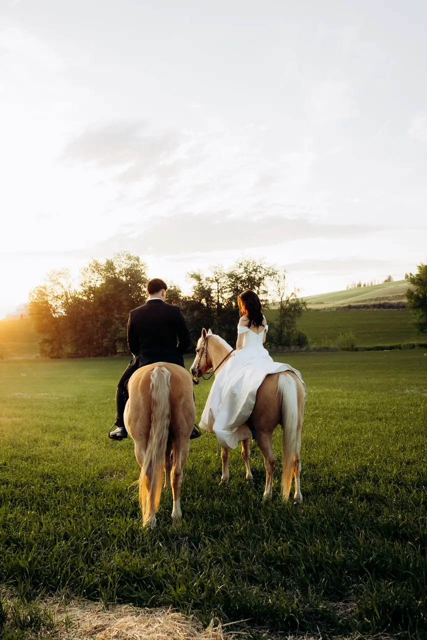 Bride and groom riding palomino horses at sunset at Barn Owl Venue in Valleyford, Washington